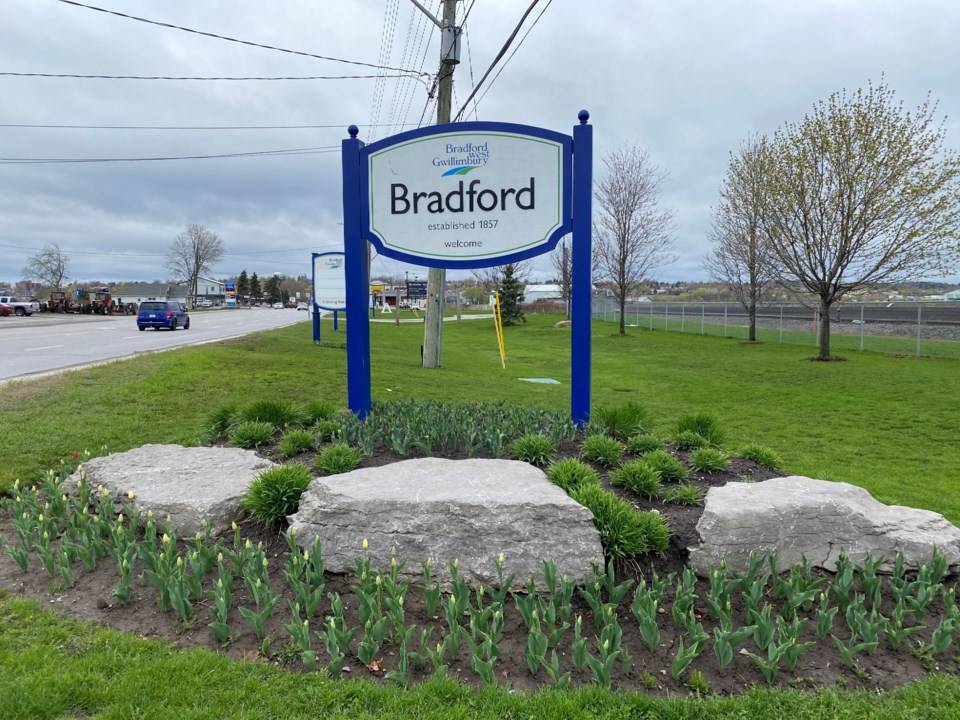 Custom arched wood double front entry door with decorative iron details and stone exterior.