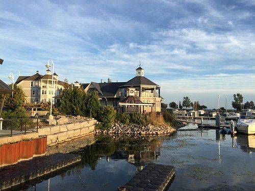 Waterfront marina in Pickering featuring boats, docks, shoreline landscaping, and lakeside buildings along Frenchman’s Bay under a blue sky.